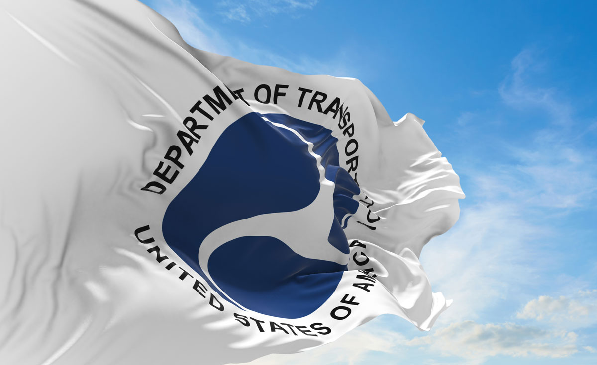 DOT flag waving in the wind against a blue sky