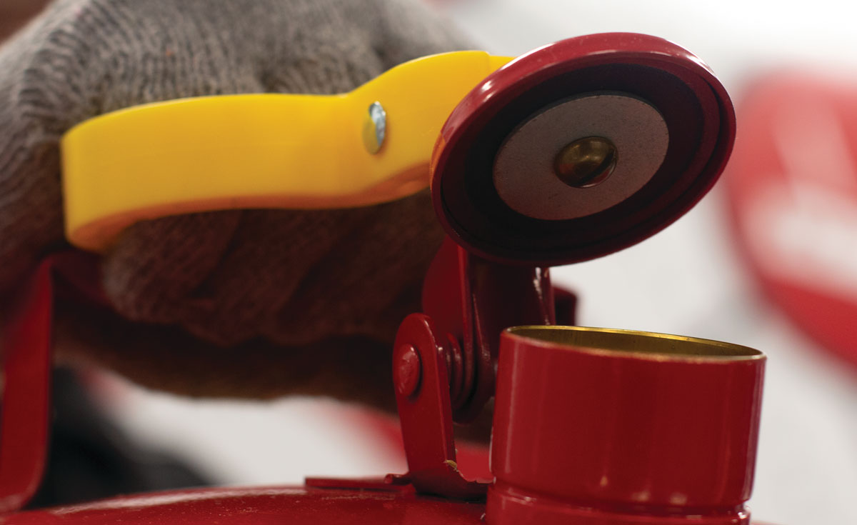 Hand opening the spout on a red Eagle safety can